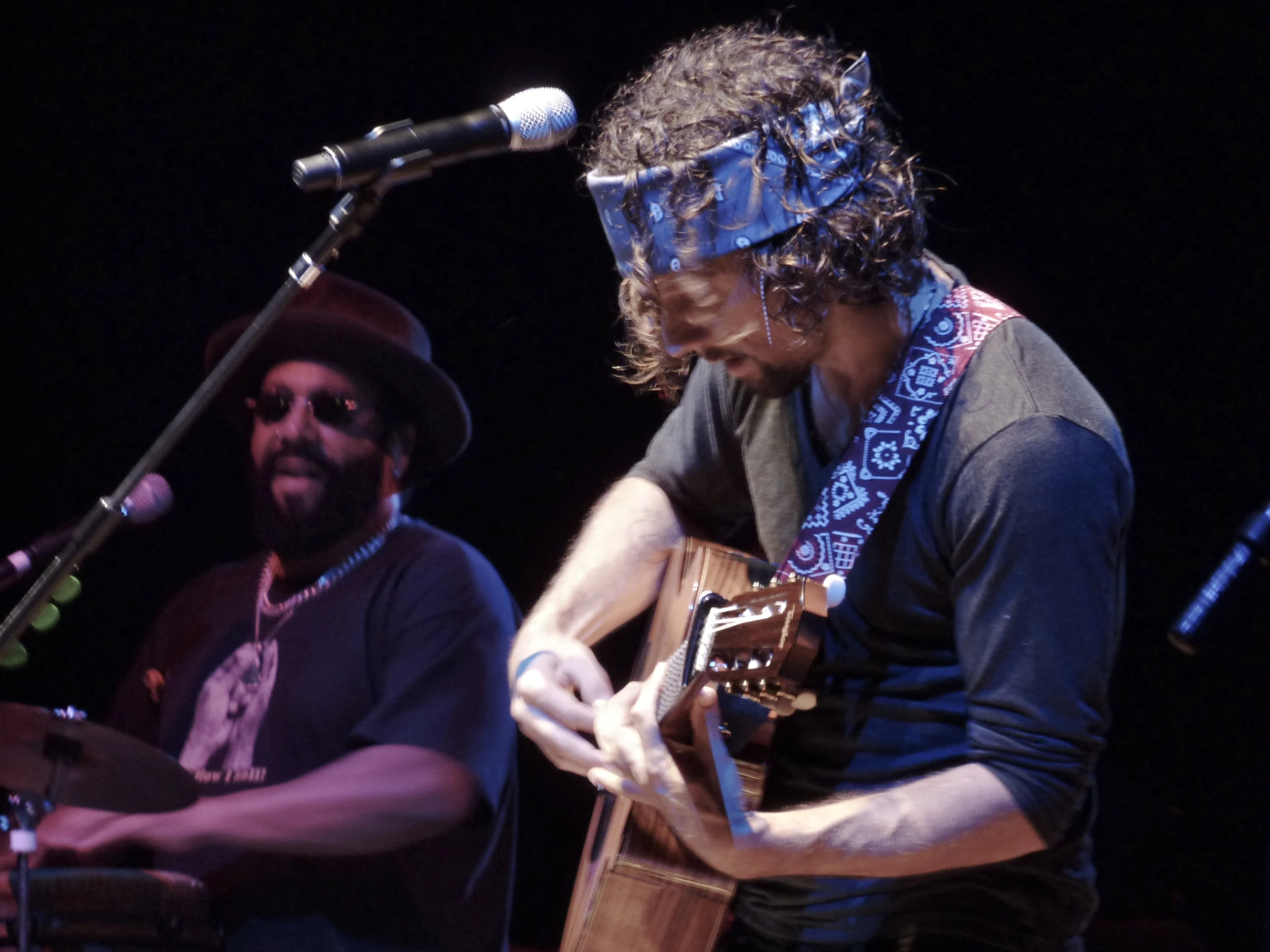 two people are at a music concert and one is playing a guitar