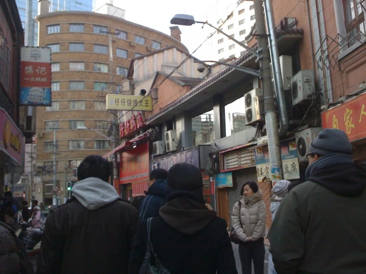 two men and woman walking through city street near tall buildings