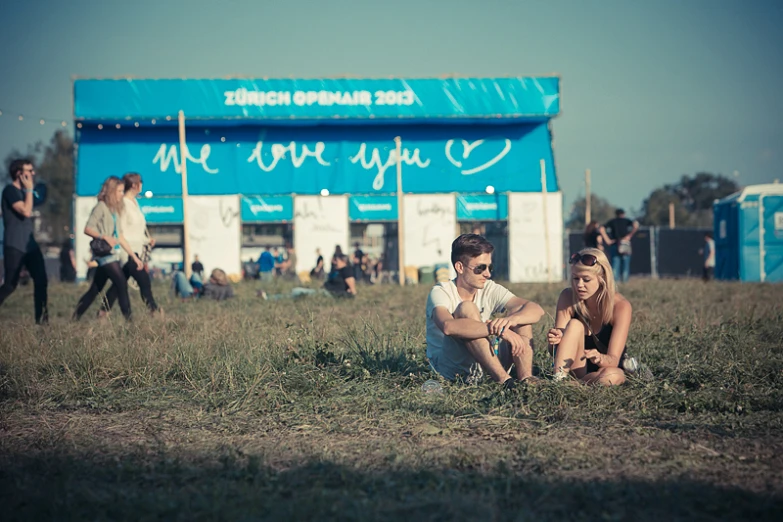 people sitting on the ground in front of a building