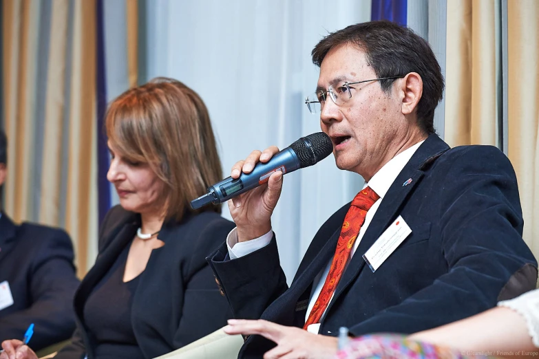 two people in suits are holding microphones