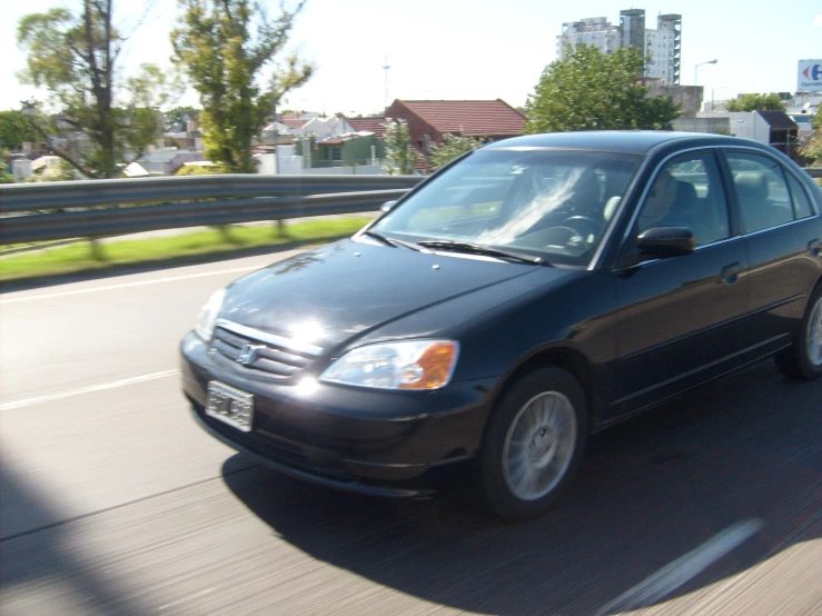 a car moving fast through the city with houses in the background