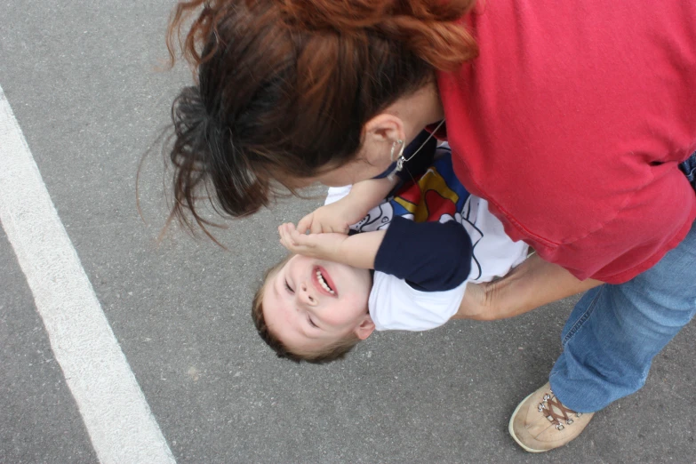 a woman helps a child put her nose up