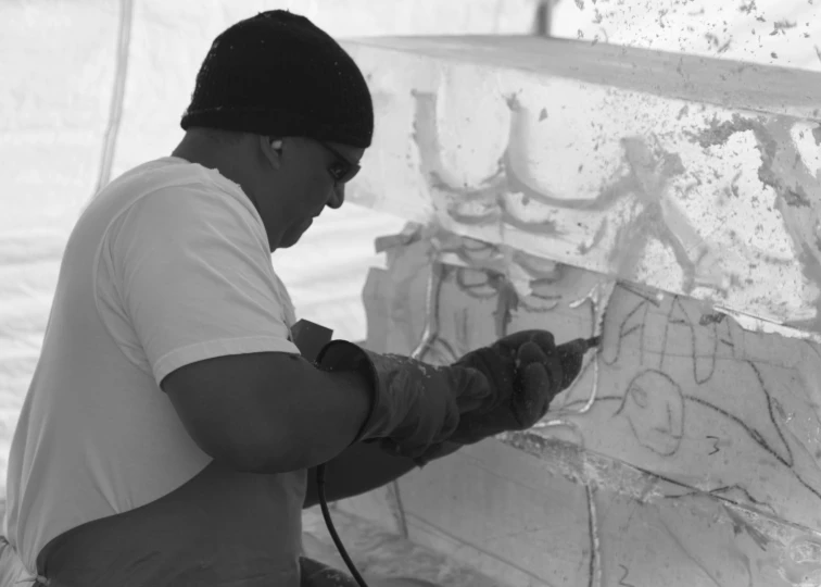 a man working on a wall with a blow dryer