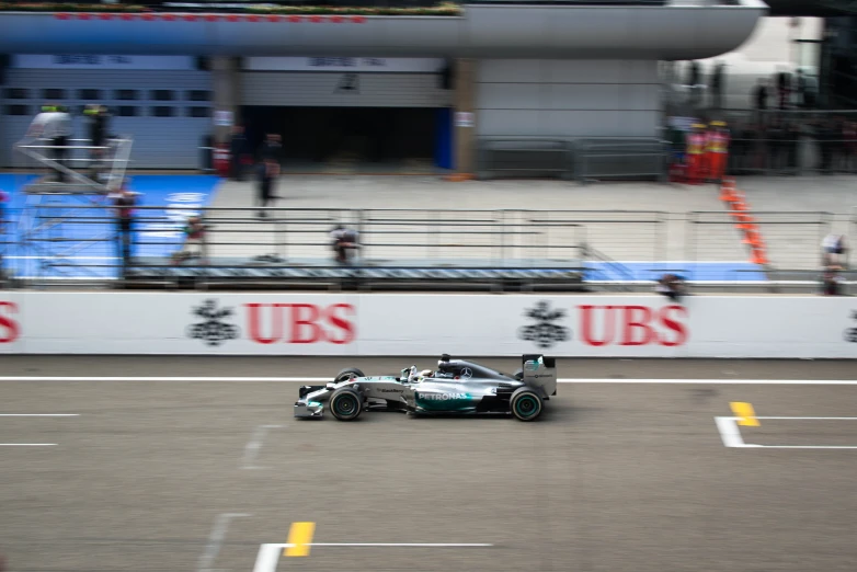 a race car drives in the street near a wall