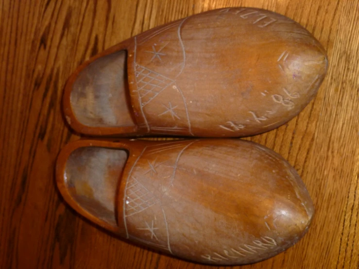 wooden slippers with handwriting on the soles that say jesus christ