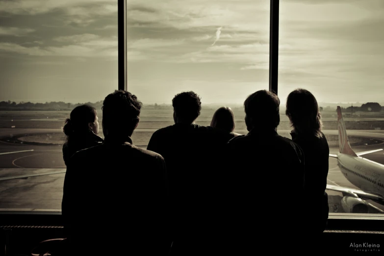 people are looking out the window at an airport