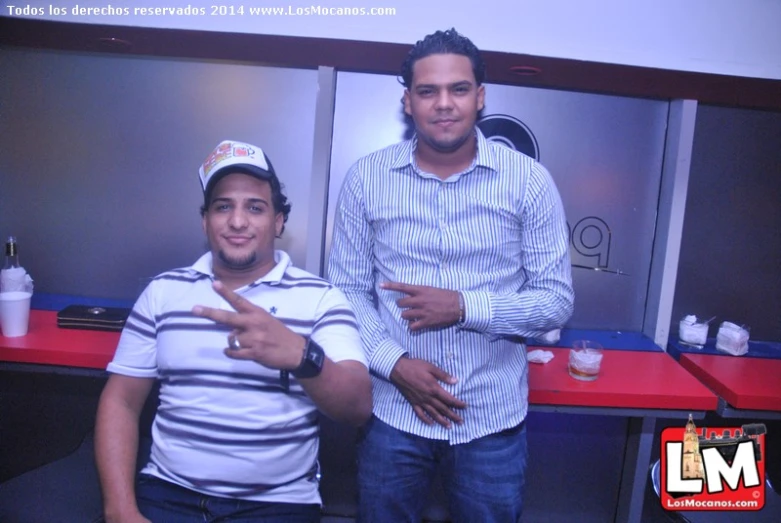 two men are posing for the camera near food stands