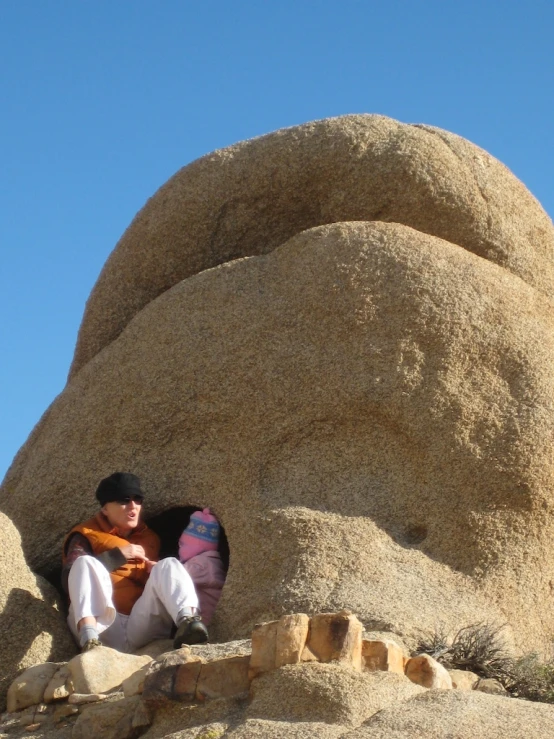 a person sitting on a rock holding a surfboard