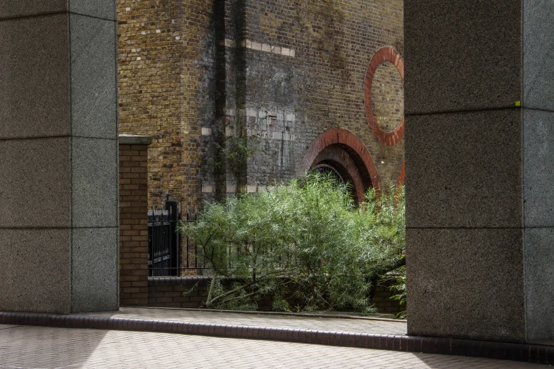 there are green trees in the city behind this brick wall