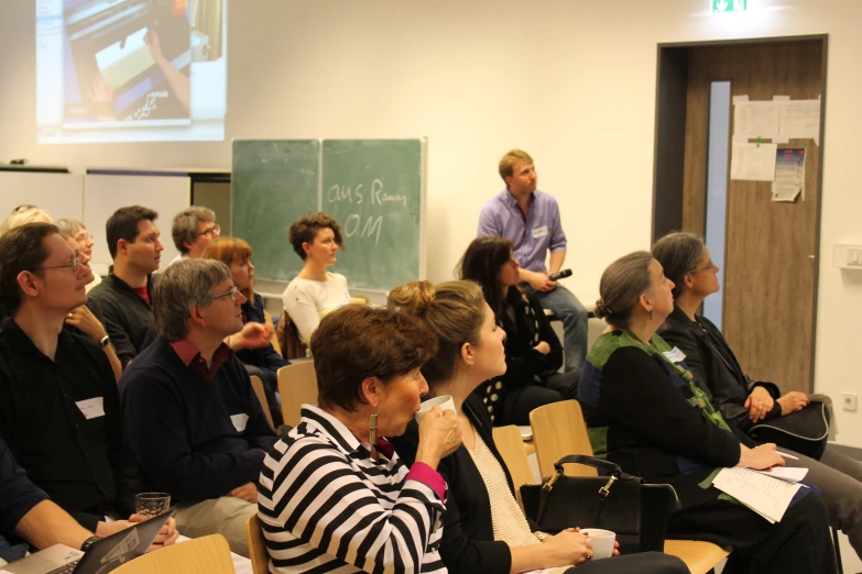 a group of people sitting in rows at a lecture