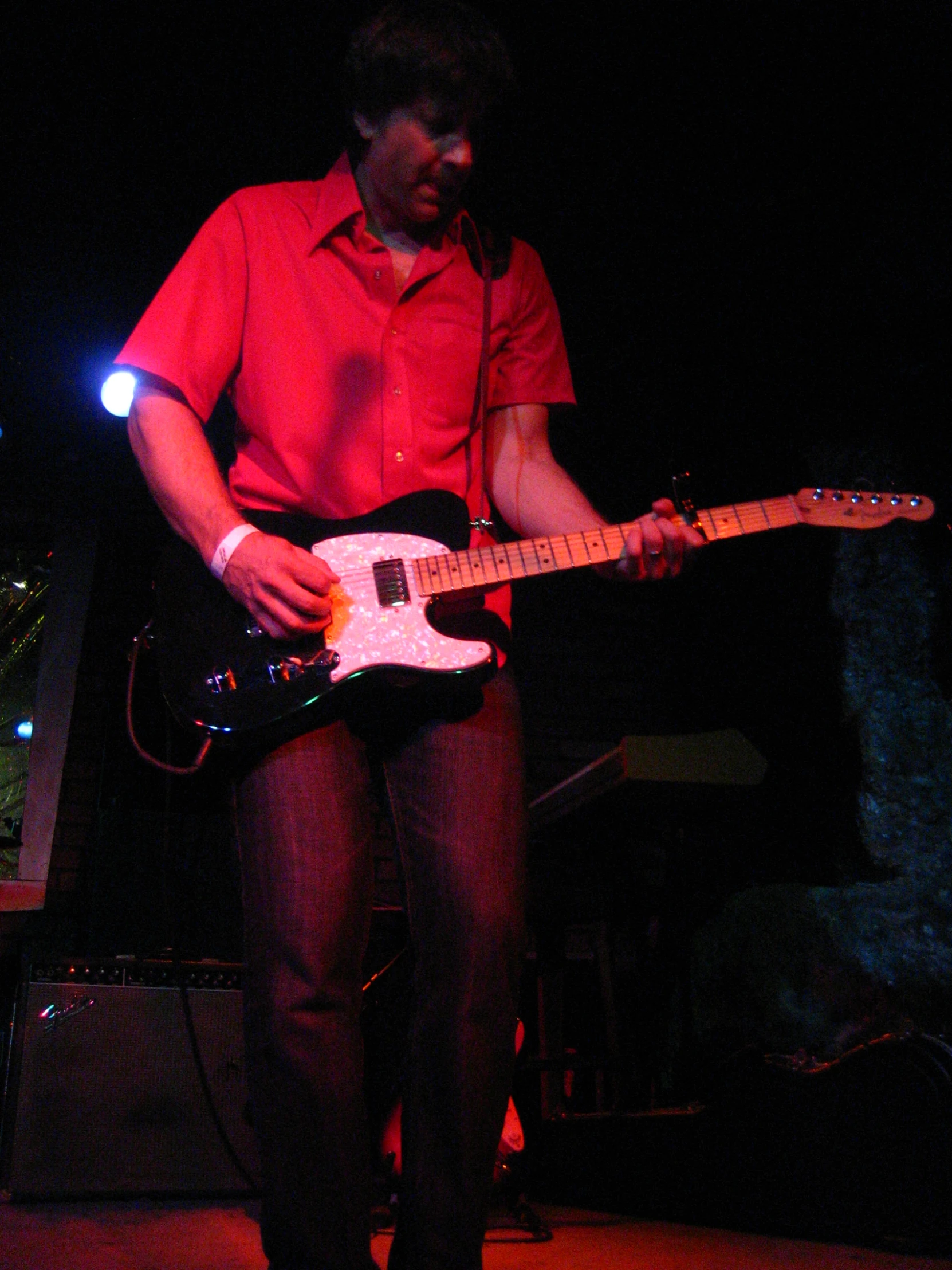 a man playing a guitar in the dark