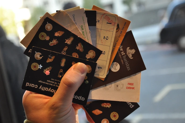 a person is holding five card - size travel stickers