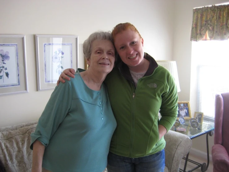 two women pose in their living room in the daytime