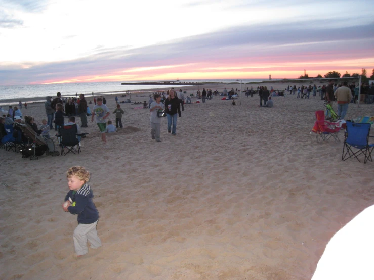 a group of people stand in the sand at a beach