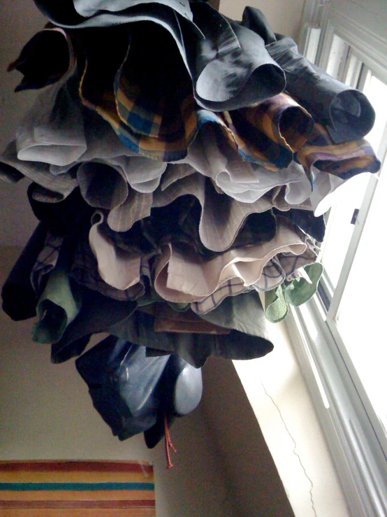 a stack of dress shirts hanging from a window