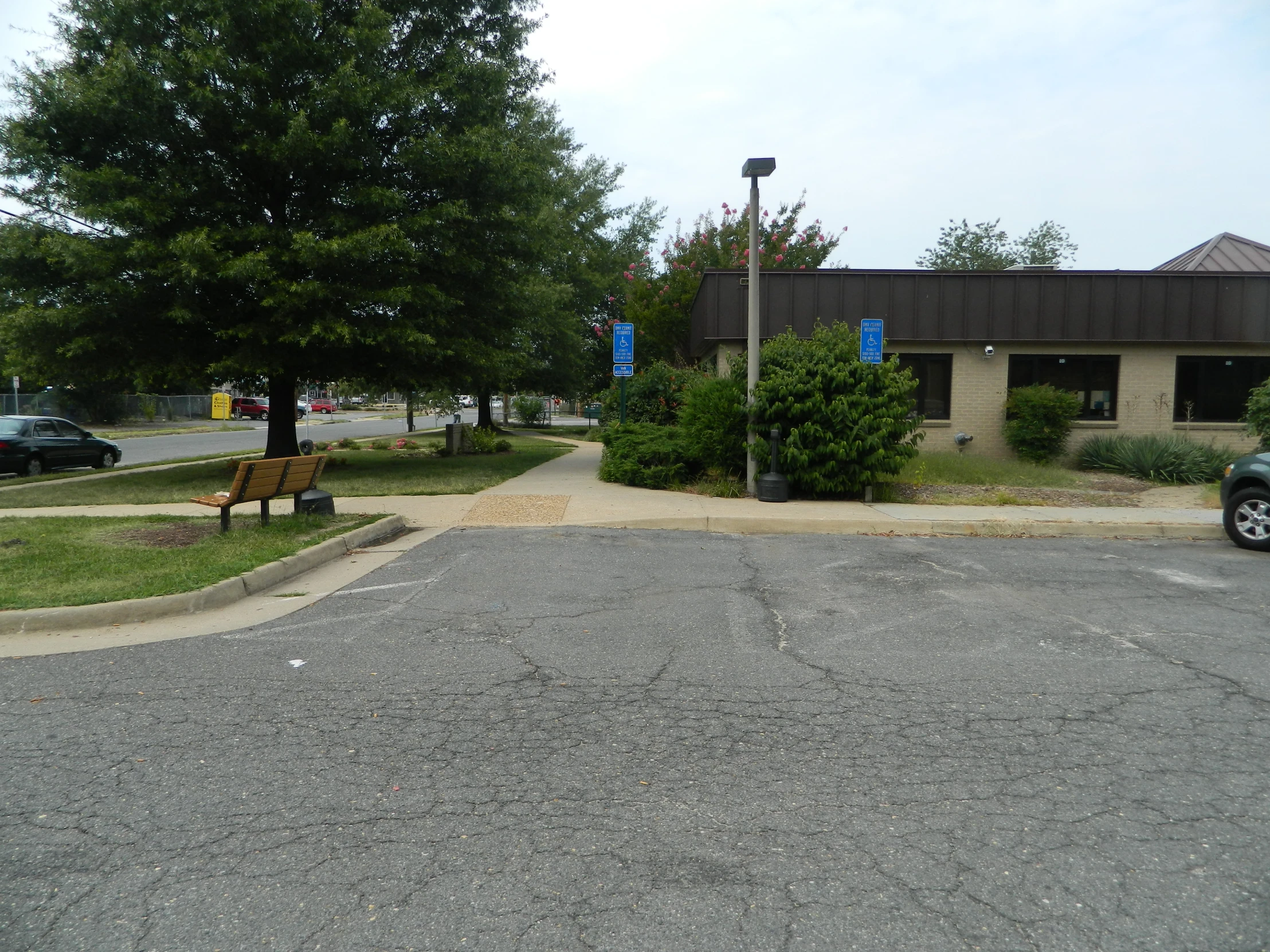 a parking lot with a bench on the curb