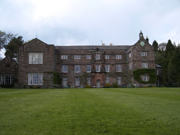 large old brick building with grass and trees