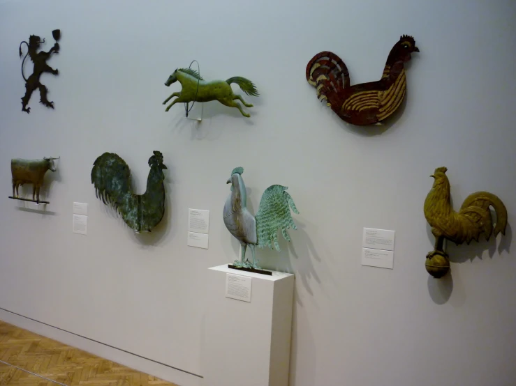 several sculptures are hung on the white wall