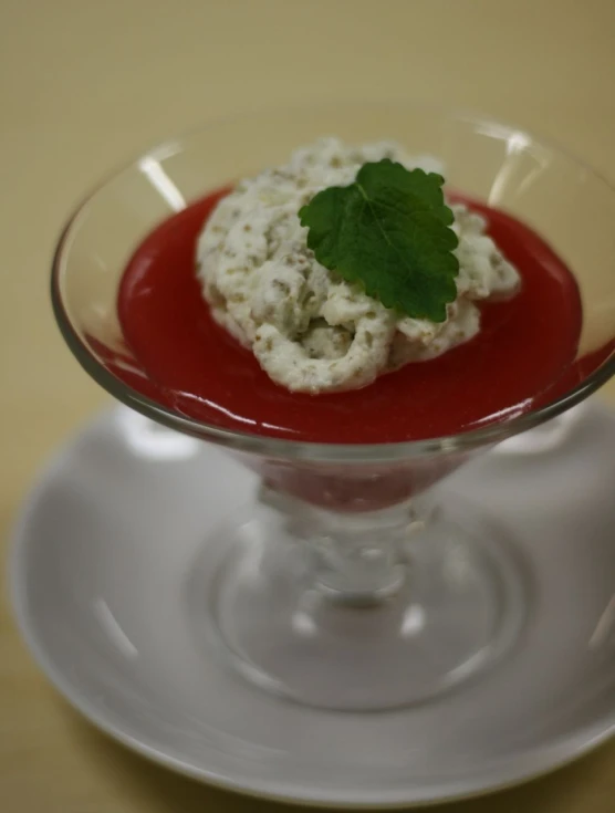 a white dessert with a green garnish in a clear glass bowl