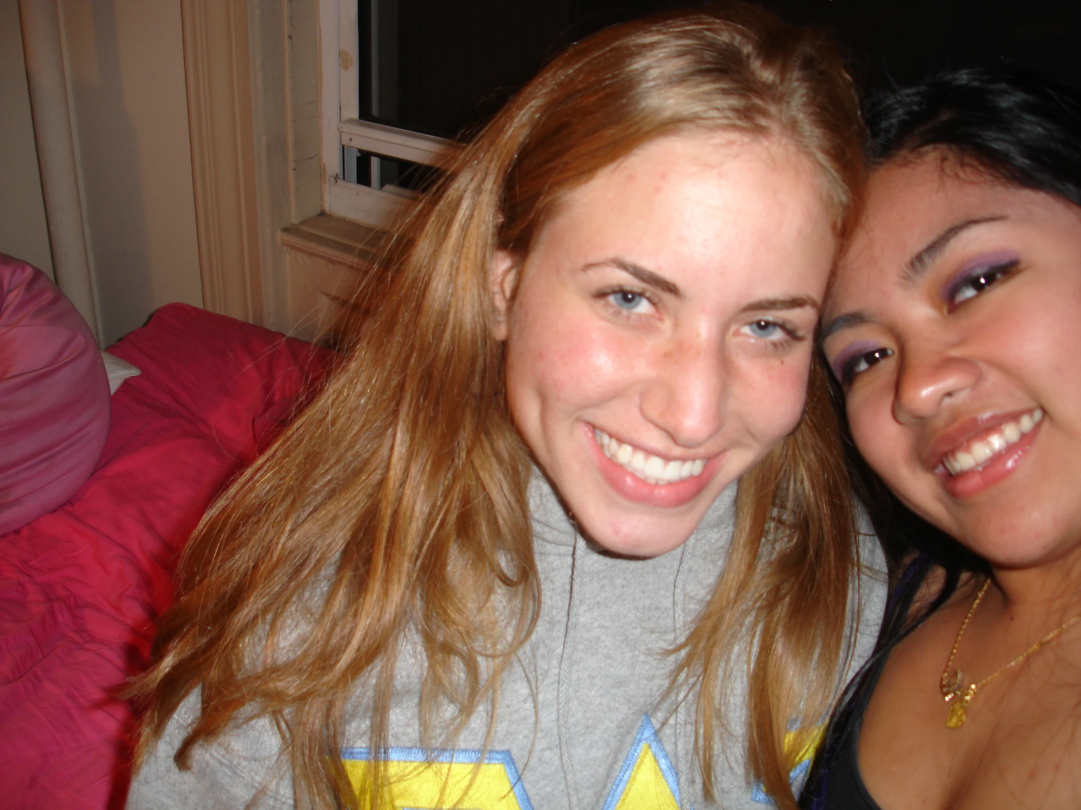 two women pose for a picture in their bedroom