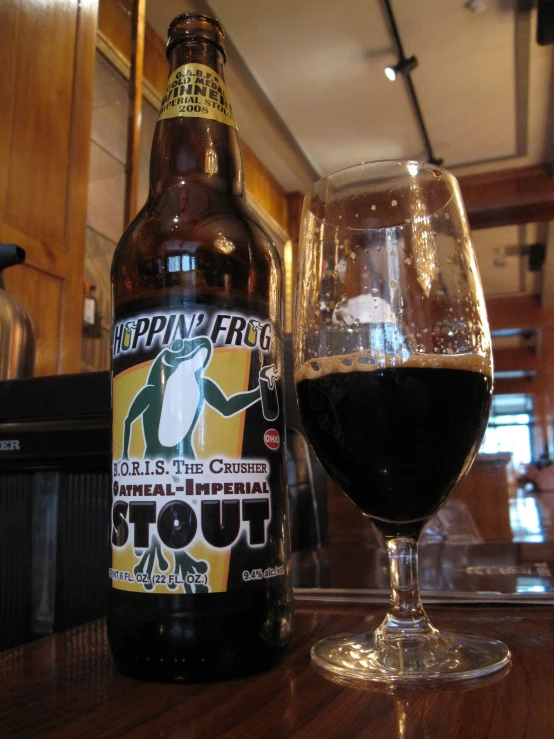 a glass and bottle of ale sitting on a table