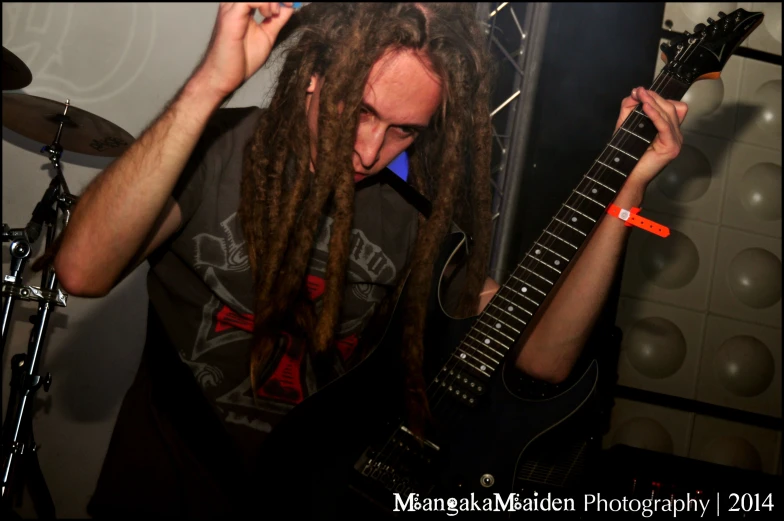a man with dreads holding up his guitar