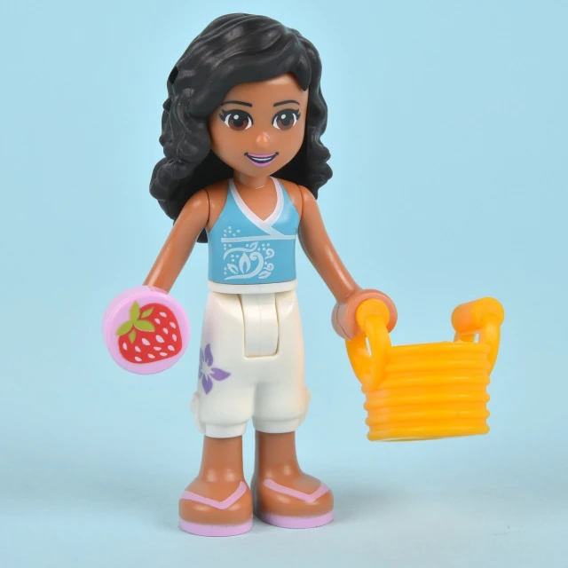 a toy figure holding a strawberries and a basket