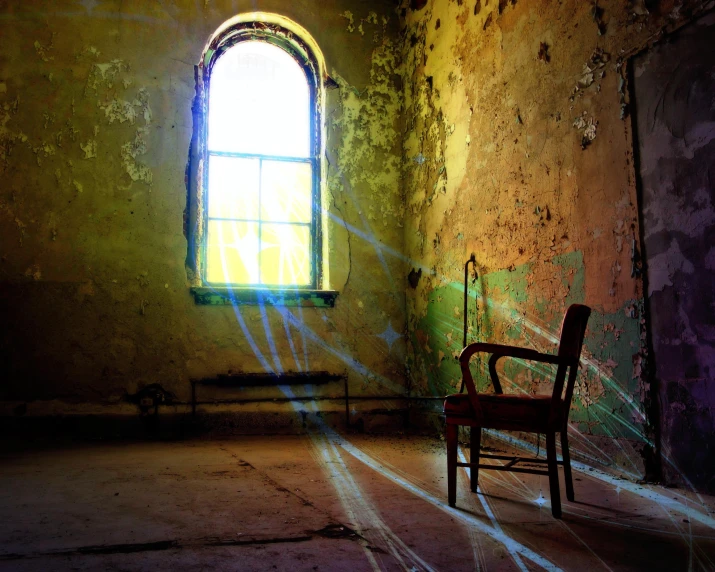 an empty room with a chair next to a large window