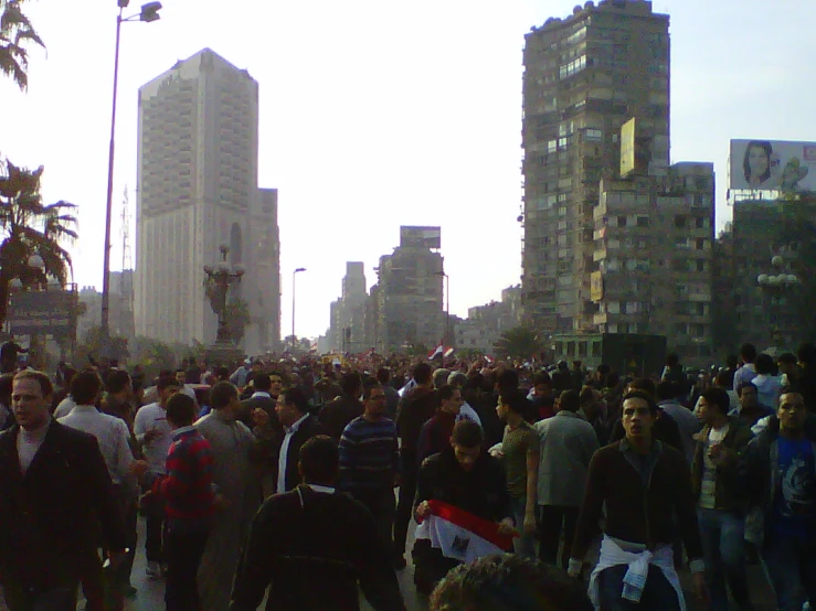 a large group of people standing near tall buildings