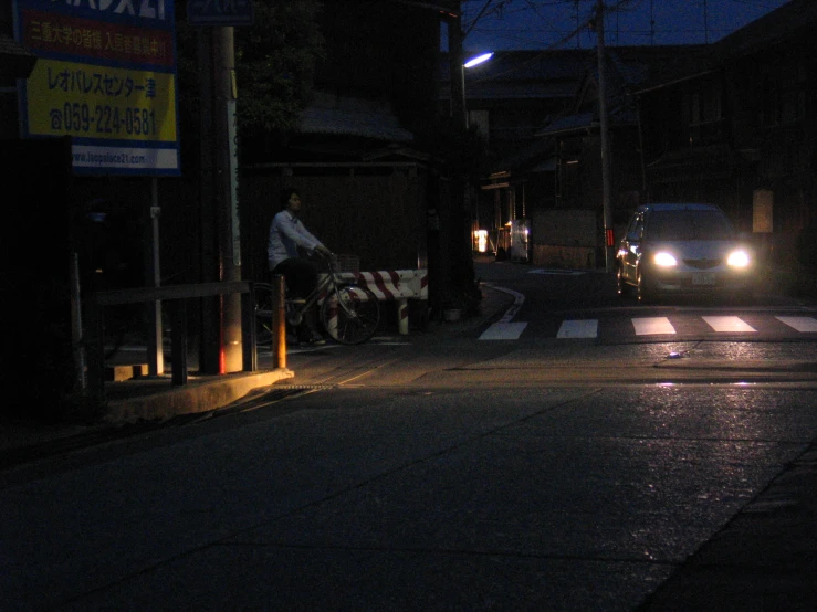 two men standing next to a bike on a dark street