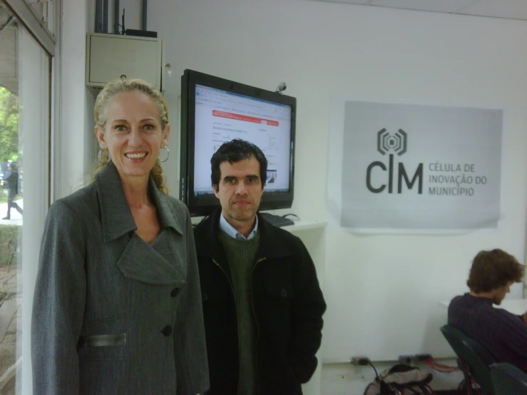 two people are standing in front of a monitor