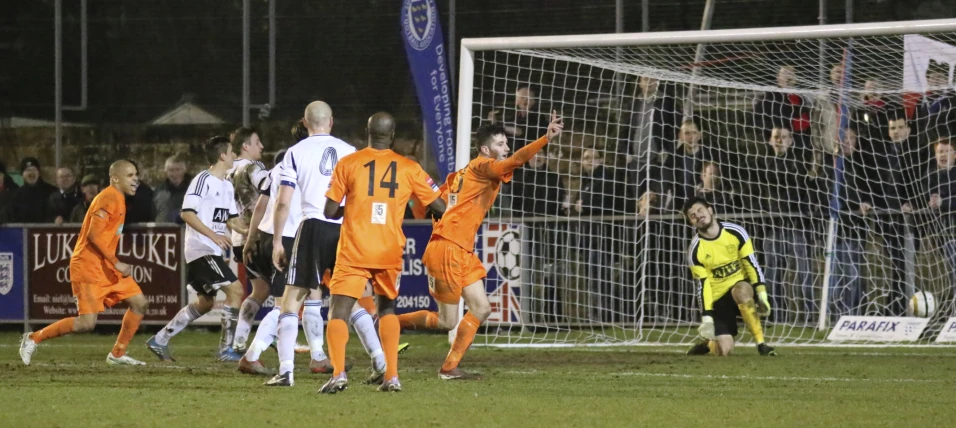 a group of people playing soccer in front of a net