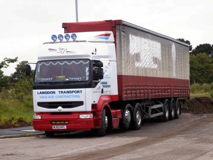 a red and white truck driving down the street