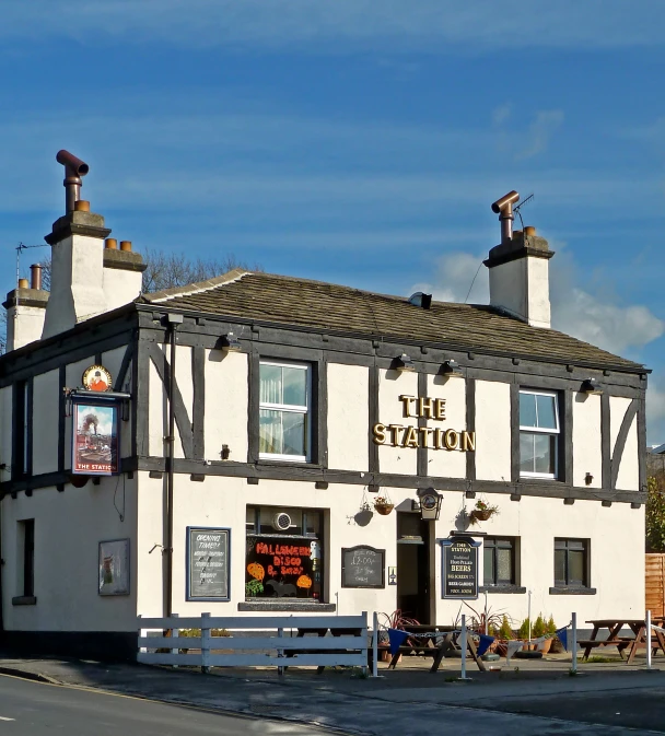 a white building with black trim sitting along side a street