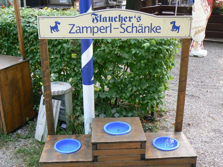 a street sign with four blue plates on it