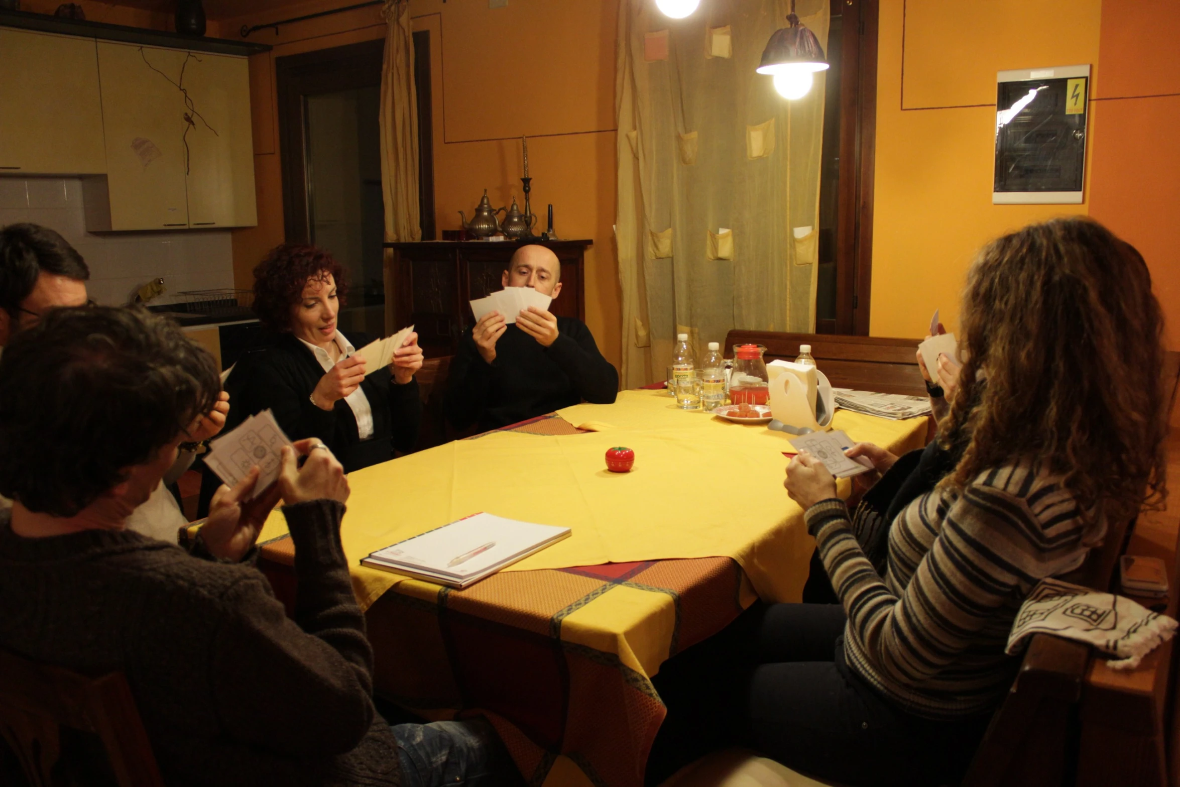 four people sitting at a table are looking at papers