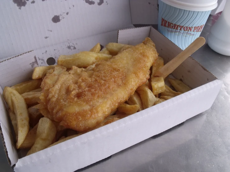 a box of fried fish and fries next to a cup of coffee