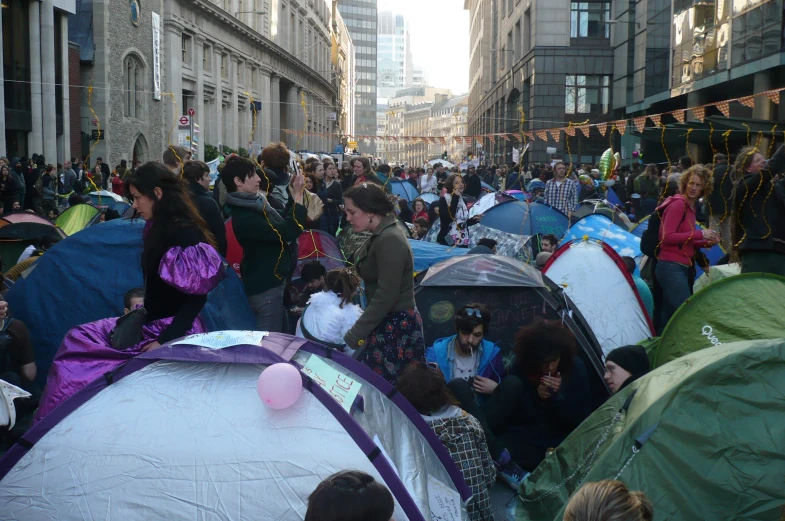 many people are gathered around with tents outside