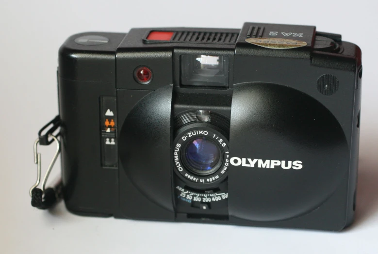 a black camera is on a table that says olimplus