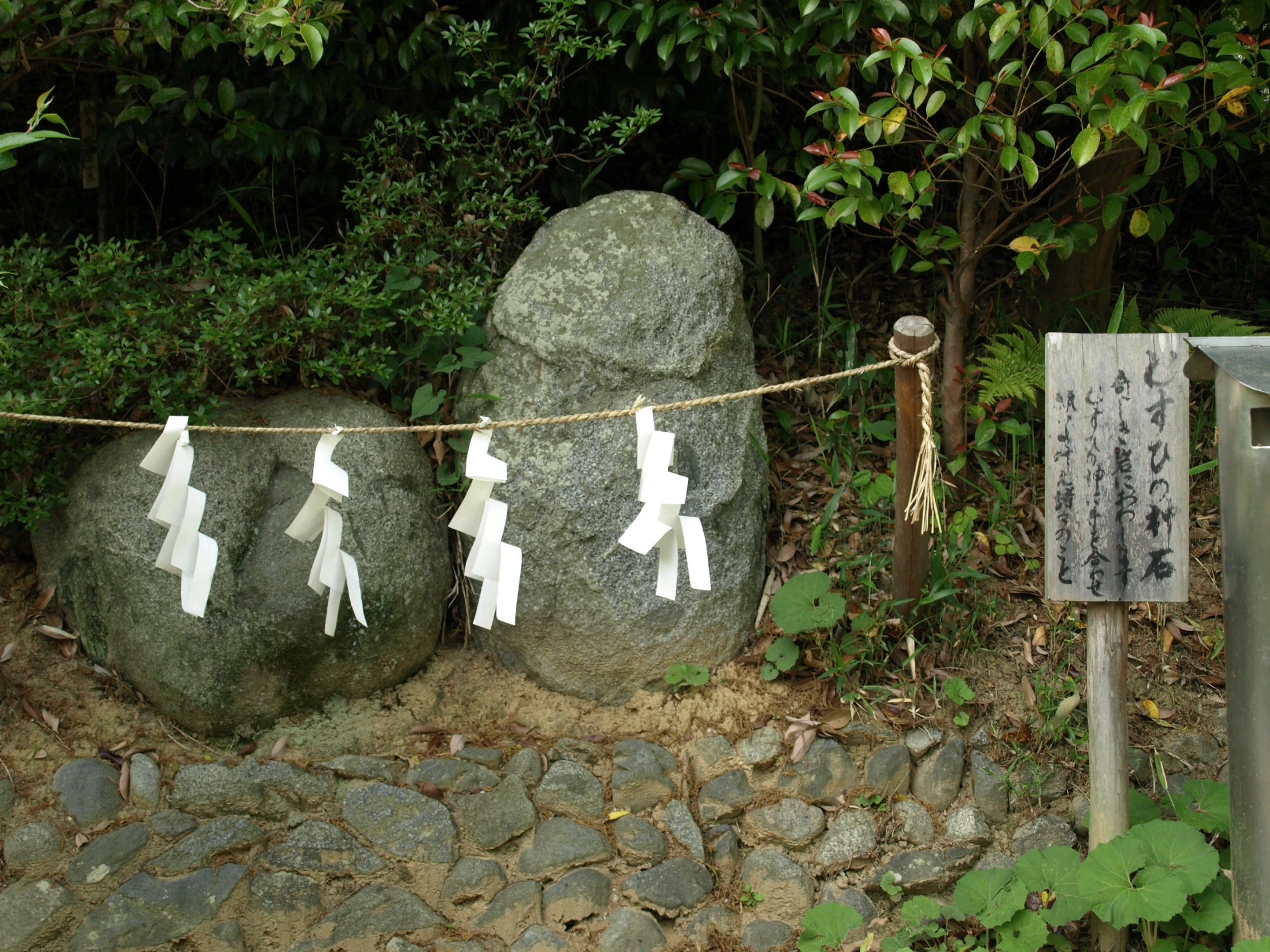 two rocks in the ground, with small figures painted on them