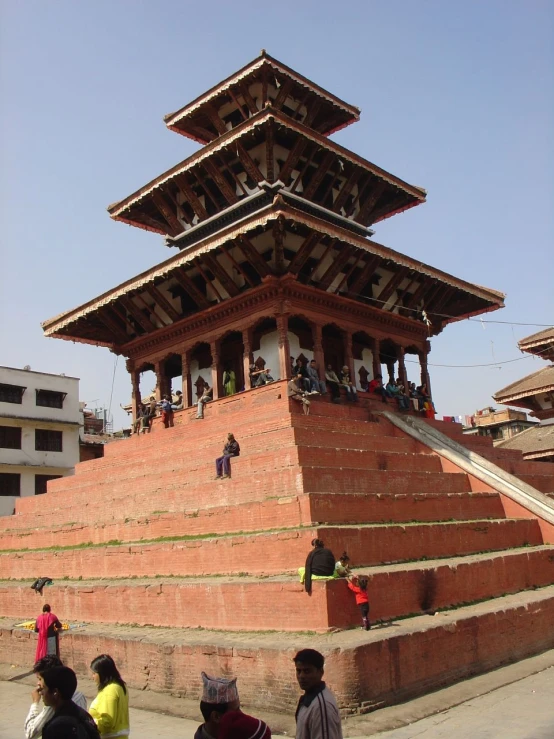 people walking up steps in front of an old building