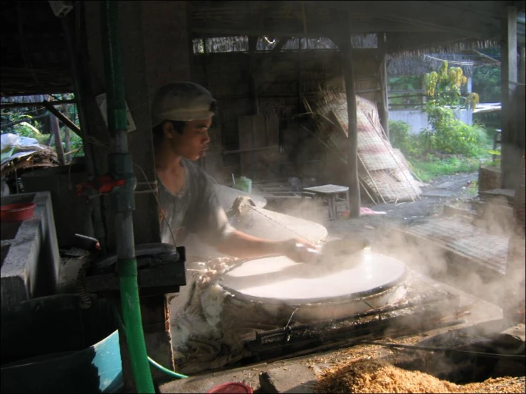 a man is stirring a drum with a saucepan