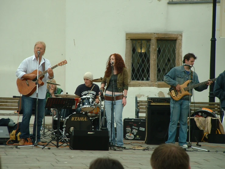 an image of musicians playing on stage with people watching