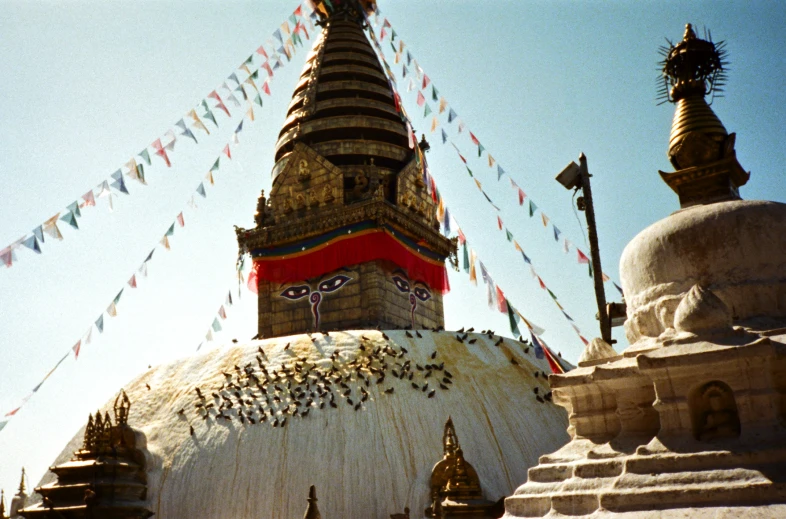 the dome of an indian temple with some colorful flags