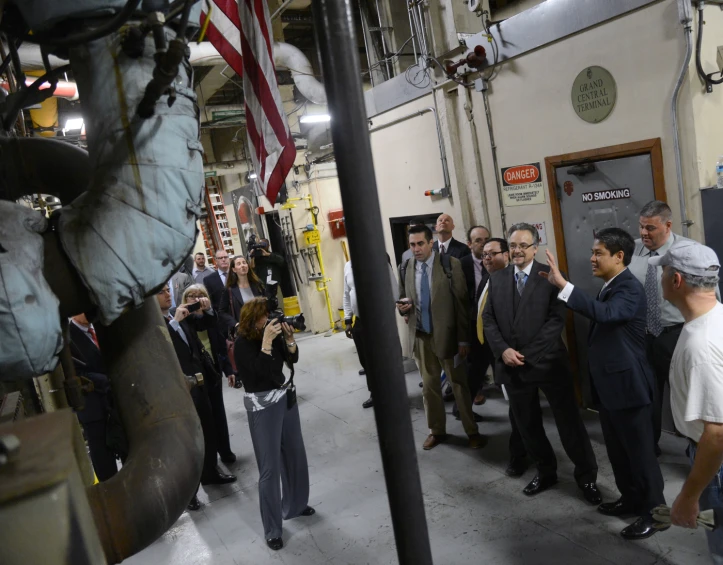 people in an industrial building and a american flag hanging on the wall