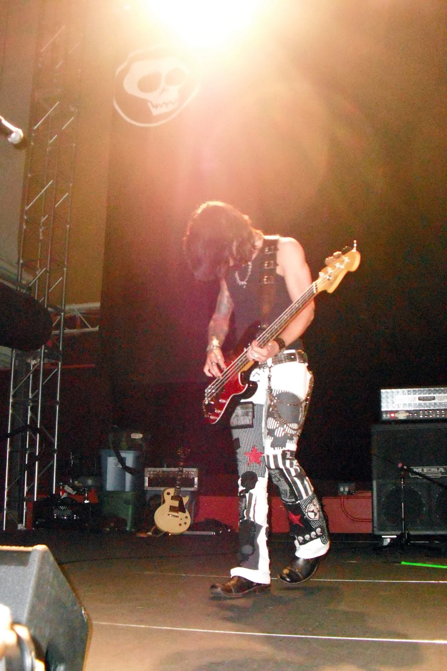 a man holding a guitar while standing on top of a stage