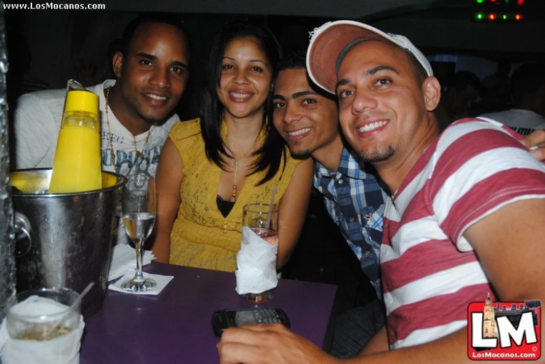 four people posing for a po in front of a camera