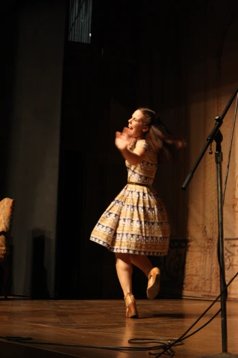 a woman on stage dressed in a vintage dress