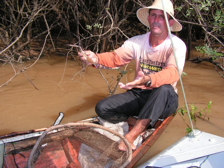 a man is sitting in the boat with a fish