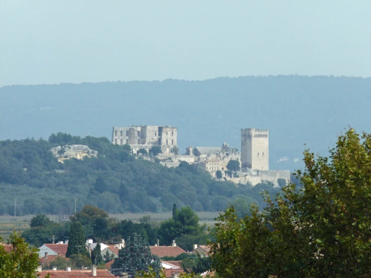 castle with a few towers stands on a hillside